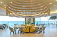 ein Restaurant mit Tischen und Stühlen und einem großen Kronleuchter in der Unterkunft Marina Hotel, Sunny Day in Sweti Konstantin