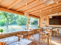 RoccaveranoAgriturismo Borghetto la radice的餐厅设有木桌、椅子和大窗户。