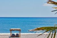 two chairs on the beach with the ocean in the background at Atlantica Dreams Resort in Gennadi