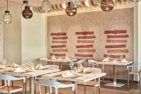 a dining room with tables and chairs and lights at Atlantica Dreams Resort in Gennadi