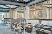 a dining room with wooden tables and chairs at Atlantica Dreams Resort in Gennadi