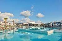 a swimming pool with chairs and umbrellas in a resort at Atlantica Dreams Resort in Gennadi