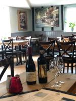 a table with two bottles of wine and a glass at Al Forno Restaurant & Inn in Norwich