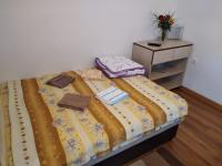 a bed with a yellow comforter and two items on it at Vikendica pored Drine Foča in Handići
