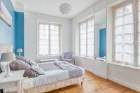 a bedroom with a bed with blue walls and windows at Ermine - Intramuros proche plage - St Malo in Saint Malo