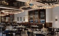 a dining room with tables and chairs and chandeliers at Sofitel Dubai The Obelisk in Dubai