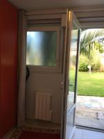 a sliding glass door with a window in a house at Olive et Pomme in Bretteville