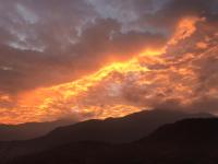 a sunset over the mountains with clouds in the sky at Bliss Bed and Breakfast in Yuchi