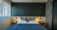 a bedroom with a large bed with a green wall at Live Hotels Bordeaux Lac in Bordeaux