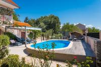 a swimming pool in a yard with a house at Holiday Home Rosko in Skradin