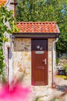 a wooden door on a stone building with a roof at Holiday Home Rosko in Skradin