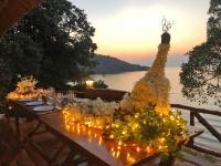 a table with candles and flowers on it with a view of the water at Banyan Bay Villas in Ko Jum