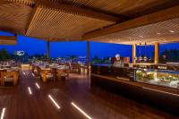 a restaurant with a bar with tables and chairs at Four Seasons Hotel in Limassol