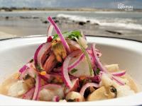Un tazón blanco de comida con cebollas rojas. en La Perla del Cabo, en Cabo Polonio
