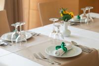 a table with glasses and plates and silverware on it at Athineon Hotel in Rhodes Town