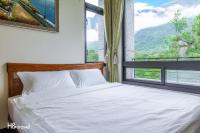 a bedroom with a white bed and a window at Qian B&amp;B (Taroko) in Jiamin