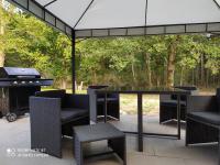 a patio with a table and chairs and a grill at Domaine les Béseaudières in Le Haut des Bordes