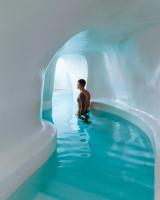 a child sitting in a pool of water in an igloo at Aspaki by Art Maisons in Oia
