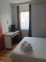 a bedroom with a bed and a desk with towels at Hôtel Hermance in Bellegarde-sur-Valserine