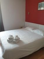 a white bed with towels on top of it at Hôtel Hermance in Bellegarde-sur-Valserine