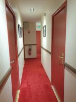a hallway with a red carpet and two doors at Hôtel Hermance in Bellegarde-sur-Valserine