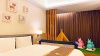 a bedroom with a bed and a window with curtains at Tsun Huang Hotel in Chiayi City