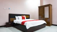 Un dormitorio con una cama grande y un armario de madera. en RedDoorz @ Jalan Cendrawasih Timika, en Timika