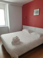 a bedroom with a white bed with a red wall at Hôtel Hermance in Bellegarde-sur-Valserine
