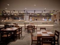 een restaurant met houten tafels en stoelen en een bar bij Delpino in Sokcho