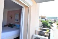 a bedroom with a bed and a balcony at Hôtel Le Claridge in Propriano