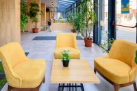two yellow chairs and a table in a lobby at Avenue Hotel Deluxe in Burgas City