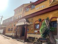 a hotel with benches in front of a building at Aranykorona Hotel in Miskolc