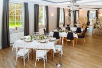 Un comedor con mesas y sillas blancas. en Landhotel Potsdam, en Potsdam