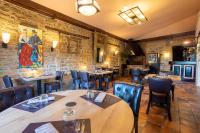 Un restaurante con mesas y sillas en una sala. en Logis Auberge du port, en Bazeilles