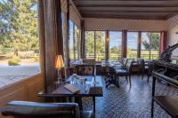 Un comedor con mesas y sillas y un gran ventanal. en Logis Auberge du port, en Bazeilles