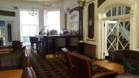 un restaurante con un bar con mesa y sillas en The Tontine Hotel, en Greenock