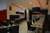 a dining room with long tables and black chairs at Spa Suites Odeón in Narón
