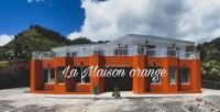 Un edificio naranja con un cartel. en La Maison Orange, en Moorea
