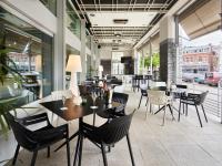 Un restaurante con mesas, sillas y ventanas. en Van der Valk Hotel Spa, en Spa