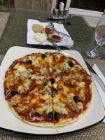 una pizza en un plato blanco en una mesa en Iris Hotel, en Toubab Dialaw