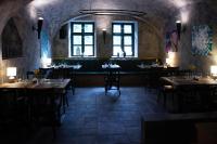 Un restaurante con mesas y sillas en una sala. en Oliva Hotel, en Veszprém