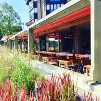 a restaurant with tables and chairs on a building at Hotel am Wasserfall in Lingen