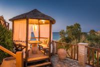 un gazebo con sedia e l'oceano di Porta del mar Beach Resort a Méson Yerakaríon