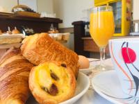 a table with bread and eggs and a glass of orange juice at Contact Hôtel Foch in Besançon