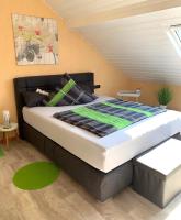 a bedroom with a large bed with a green blanket at Gästehaus Am Radweg in Blieskastel