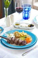 a plate of food with meat and vegetables on a table at PortoBay Serra Golf in Santo António da Serra