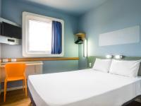 Un dormitorio con una cama blanca y una ventana. en Ibis Budget Araraquara, en Araraquara