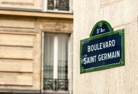 a green street sign on the side of a building at TinyHouse Inn Saint-Germain-des-Près in Paris