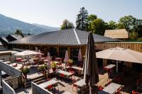 a restaurant with tables and umbrellas in front of a building at Village Vacances le Bérouze in Samoëns