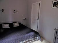 - une chambre avec un lit noir et une porte blanche dans l&#39;établissement Chambres d&#39;hôtes à Raveau, à Raveau